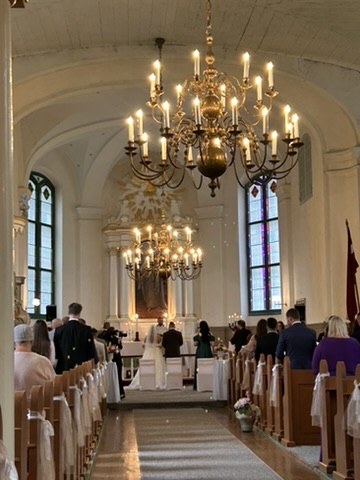 Lēdurgas baznīcas interjers ar soliem un lustrām